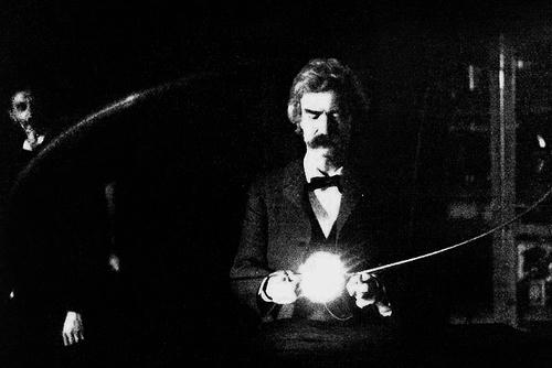 Mark Twain in the lab of Nikola Tesla holding Tesla's experimental vacuum lamp